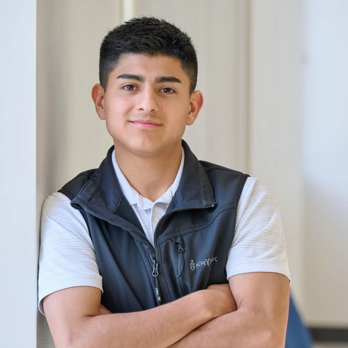 Ismael Valadez smiles indoors with arms folded