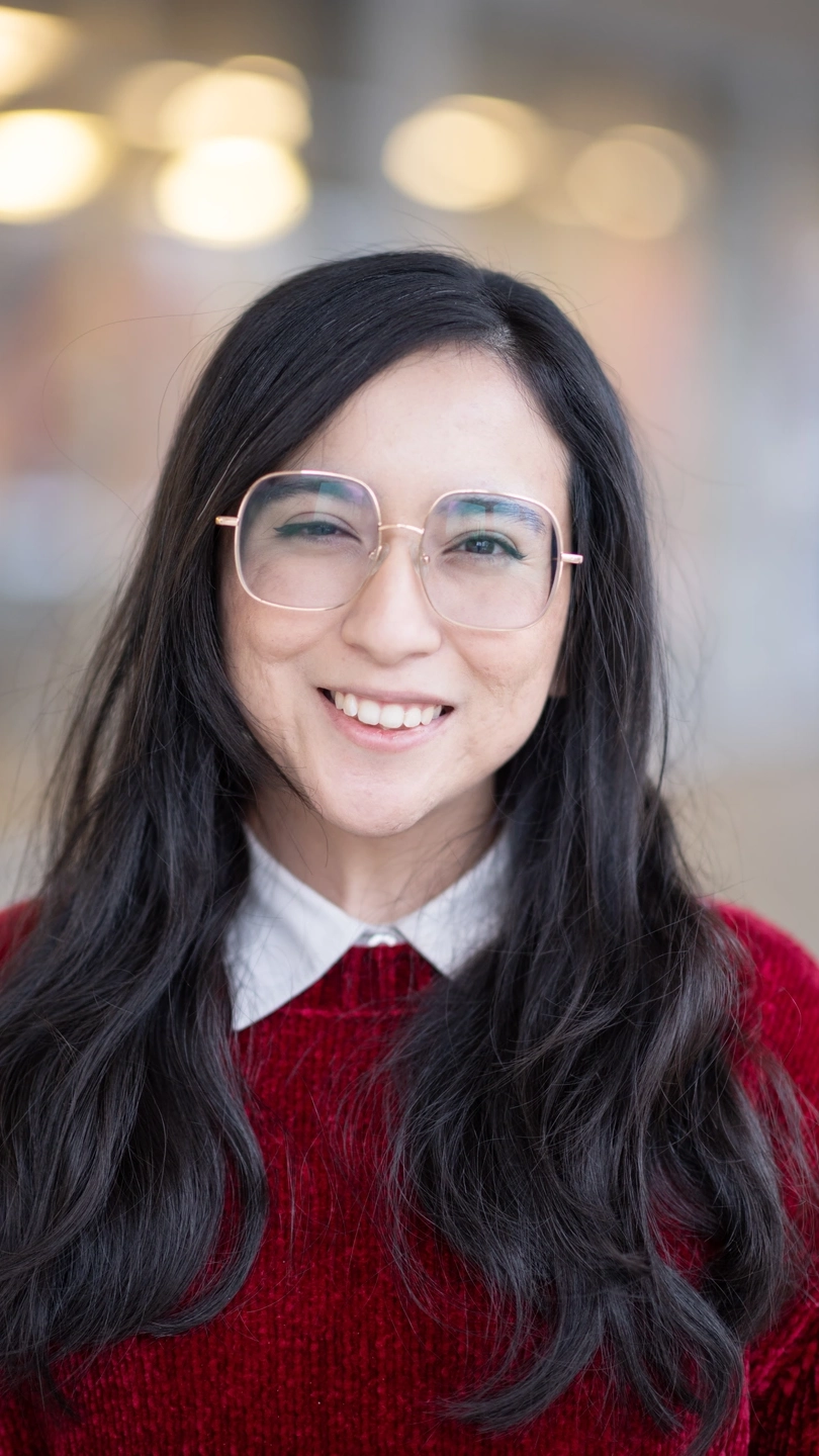 A portrait of a woman wearing a red sweater.