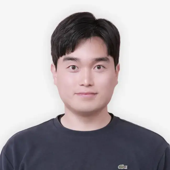 Headshot of a person with short black hair wearing a navy blue shirt against a white background.