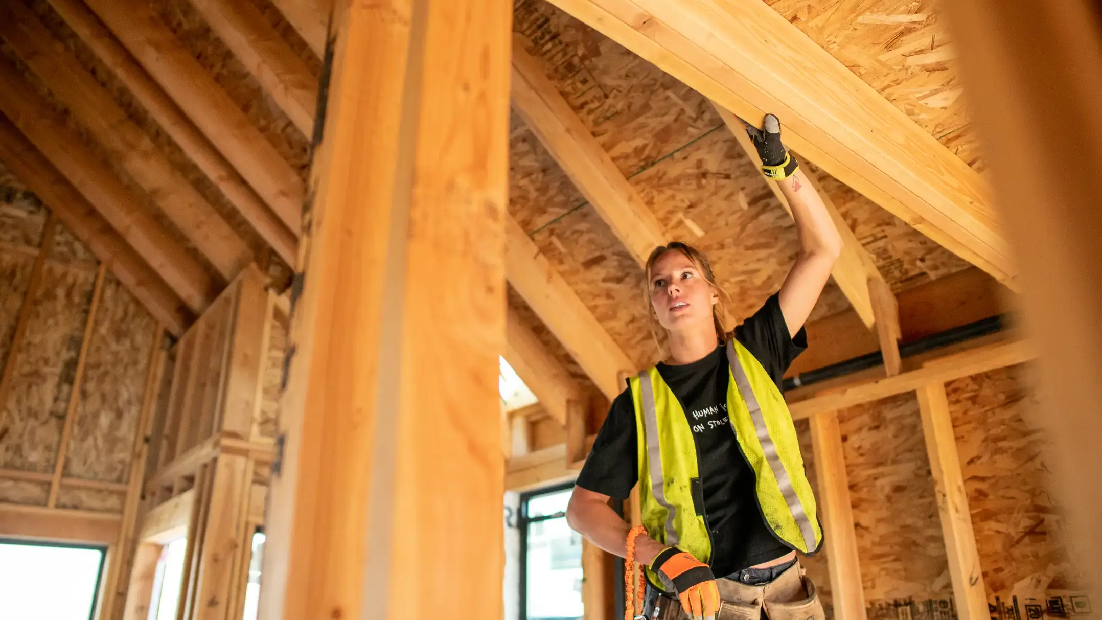 UIdaho student in construction gear, working on the interior of a new building.