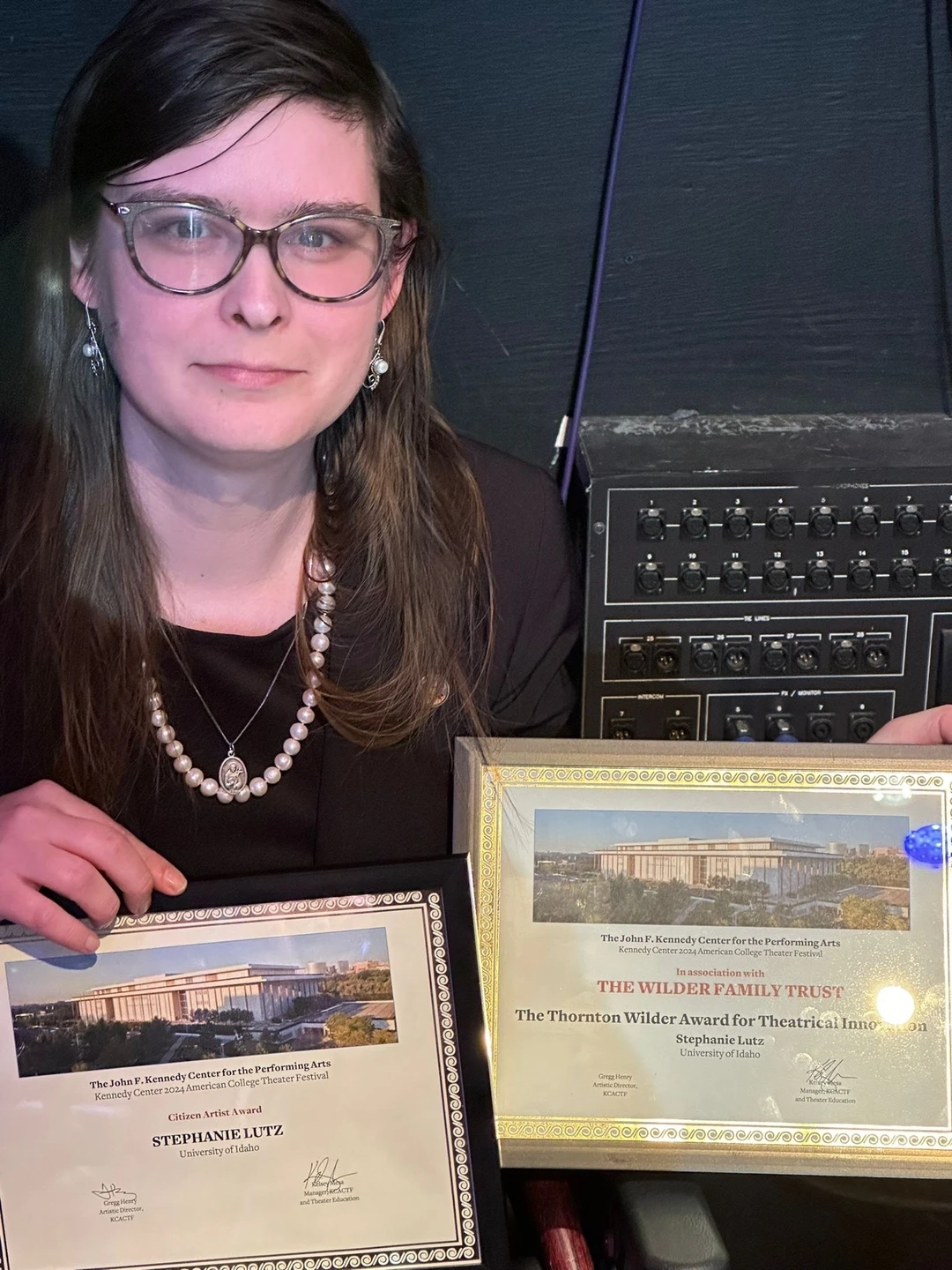 Woman holding two certificates