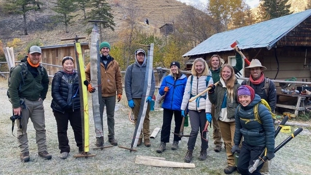 Students stand with hiking tools