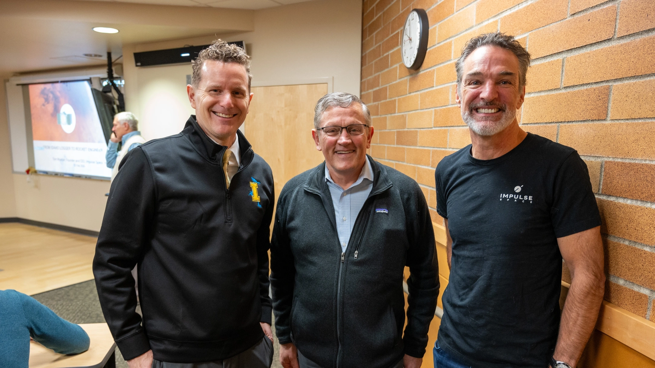 Tom Mueller poses with two campus leaders