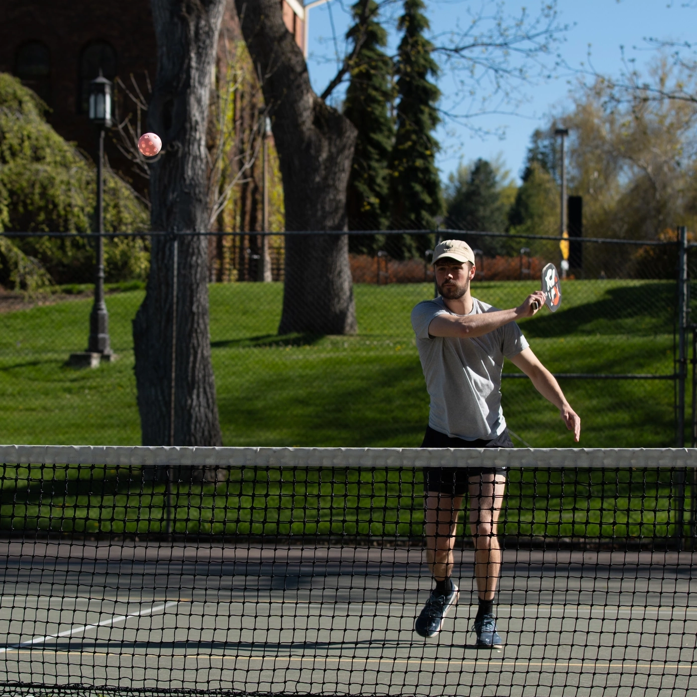 Students playing pickle ball on the Administration Building lawn tennis courts on Ӱֱ campus in the spring.