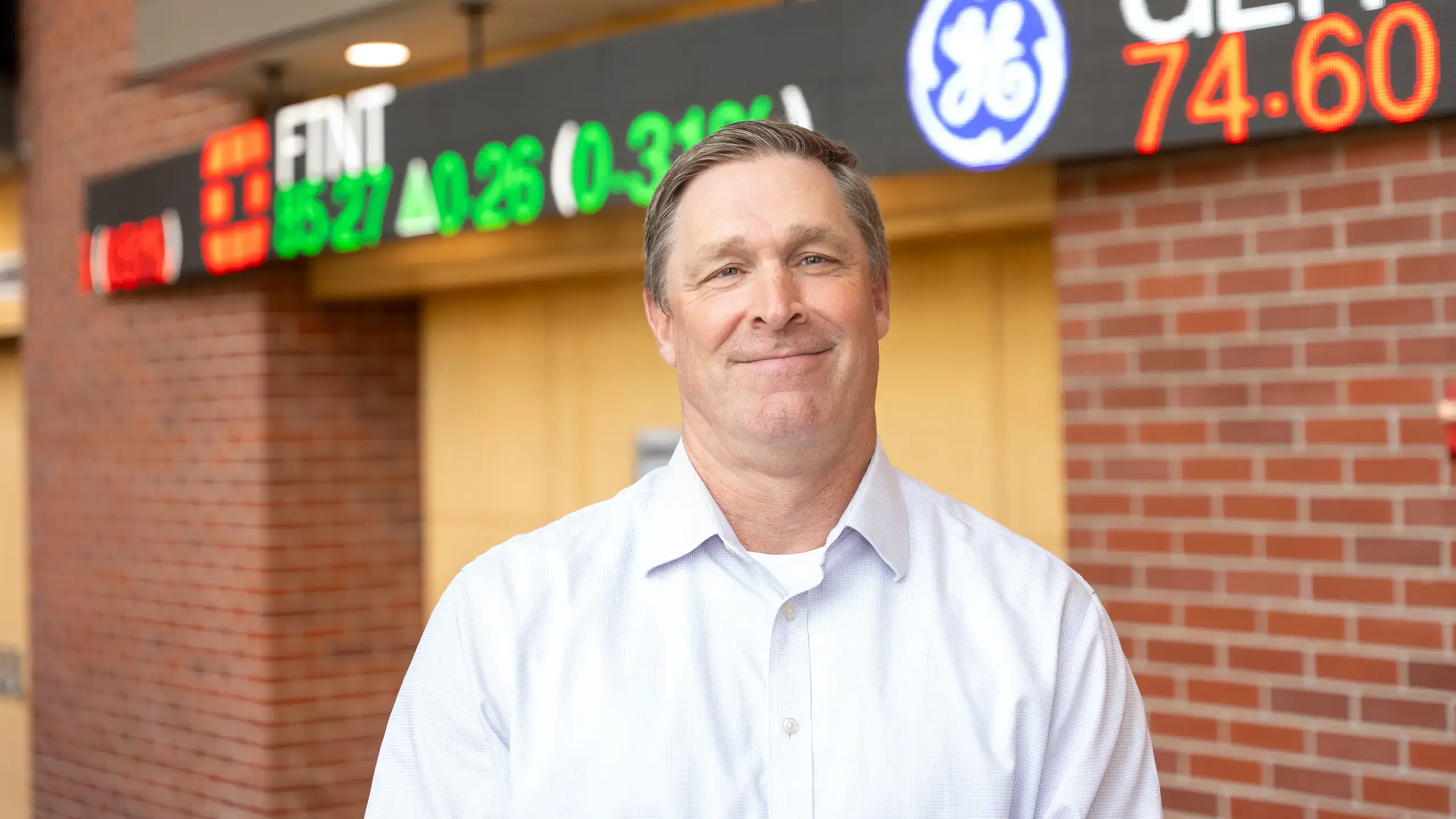 Brian "Duff" Bergquist, Senior Instructor of Finance and Barker Trading Program Director in the College of Business and Economics, is photographed with the stock ticker board in the J.A. Albertson Building on Wednesday, October 1, 2025.