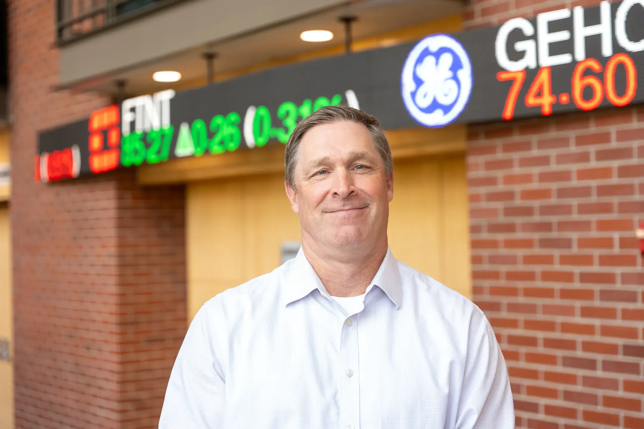 Brian "Duff" Bergquist, Senior Instructor of Finance and Barker Trading Program Director in the College of Business and Economics, is photographed with the stock ticker board in the J.A. Albertson Building on Wednesday, October 1, 2025.