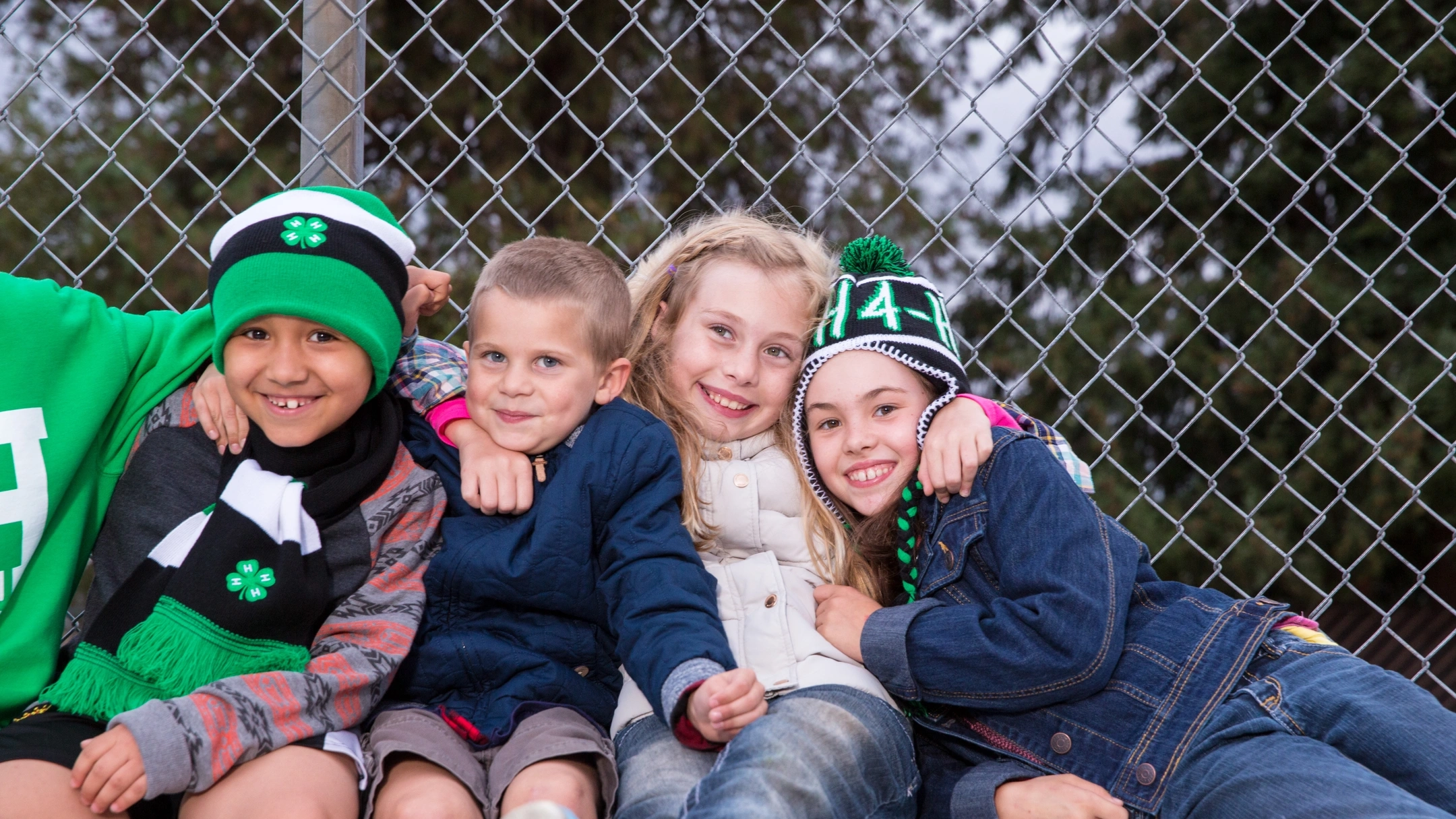 Children in 4-H apparel hold each other tight for a photo