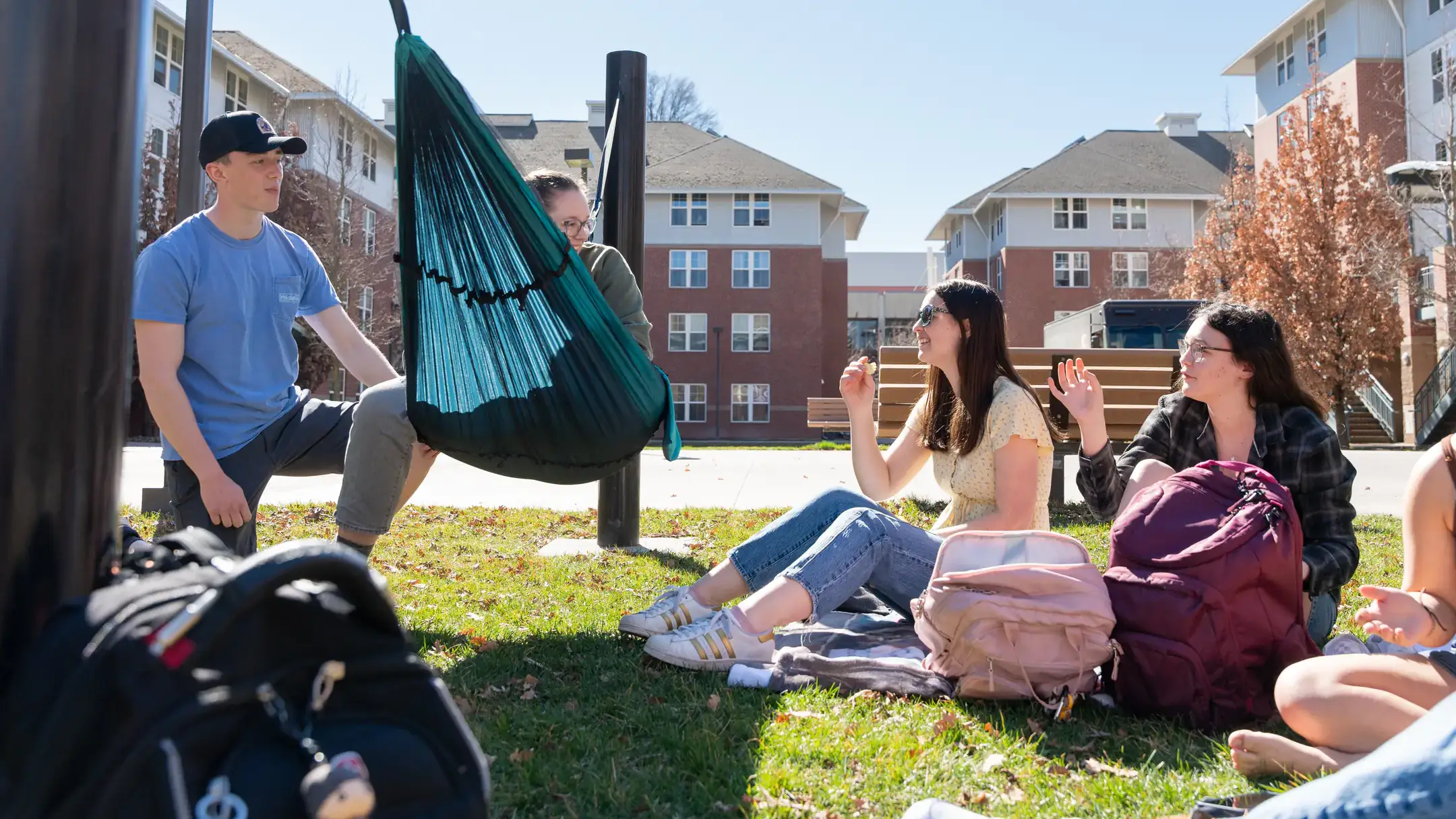Students outdoors with a hammock at the Living and Learning Community on the University of Idaho campus.