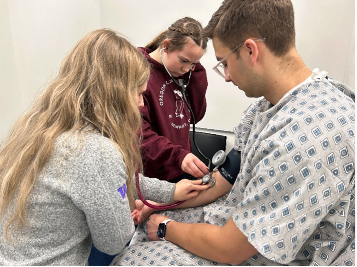 Student takes vitals of mock patient.
