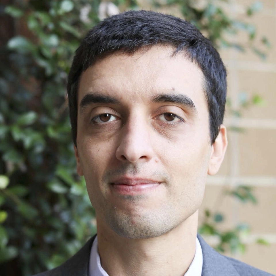 A headshot of a man in a suit.
