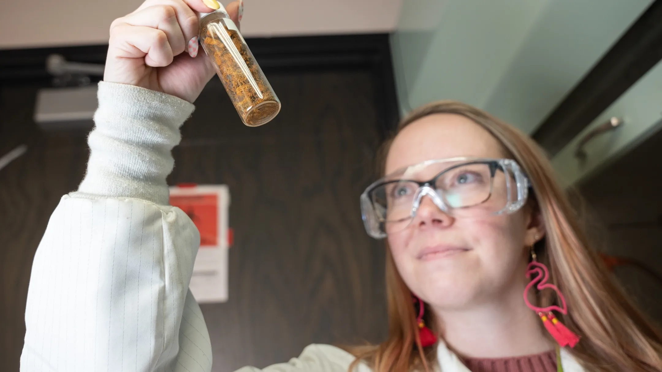 Woman holds beaker of dirt