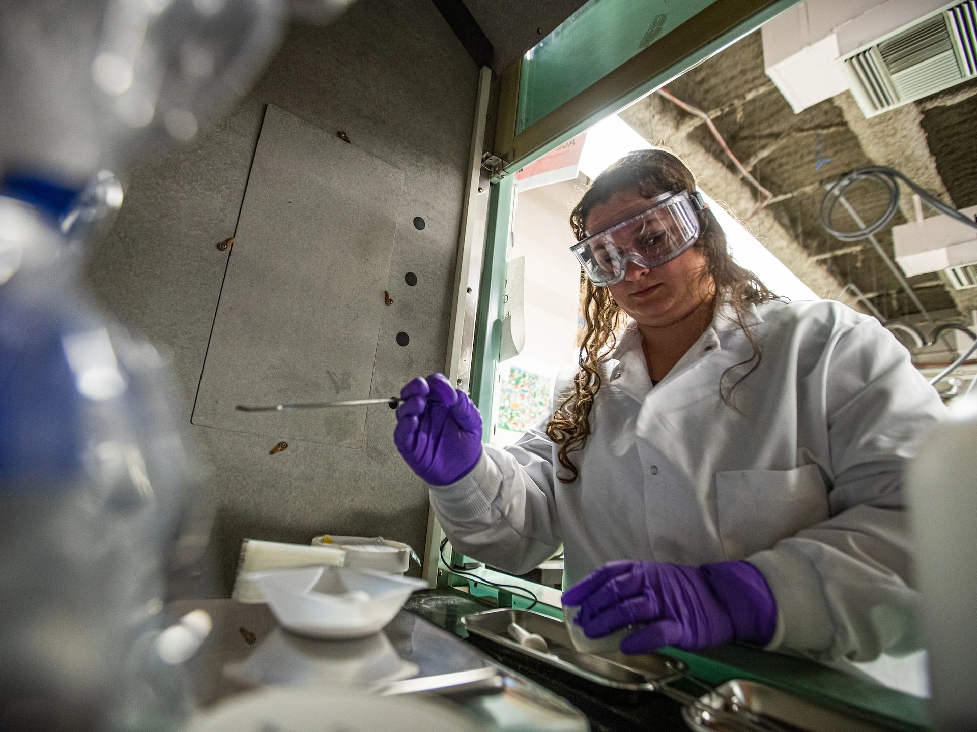 Girl measuring vial in laboratory.