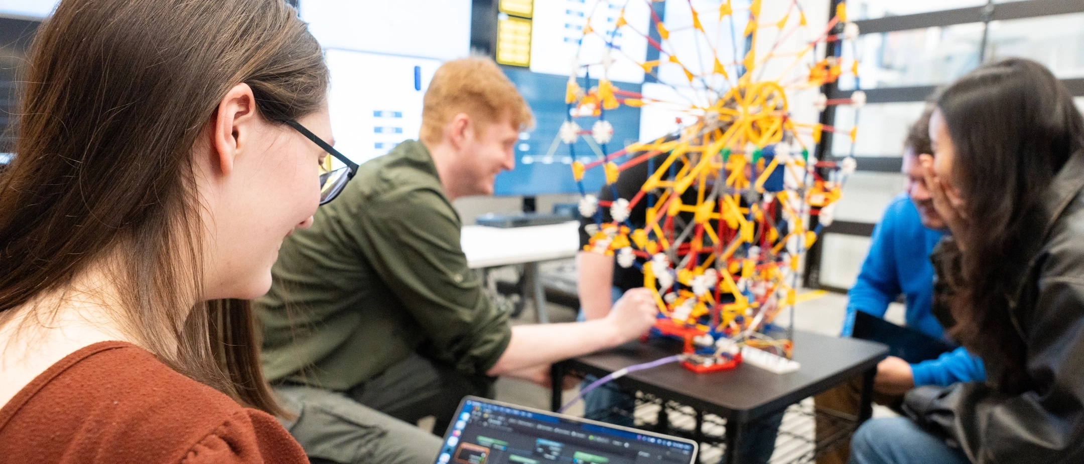 Students showing off a replicate model of a ferris wheel