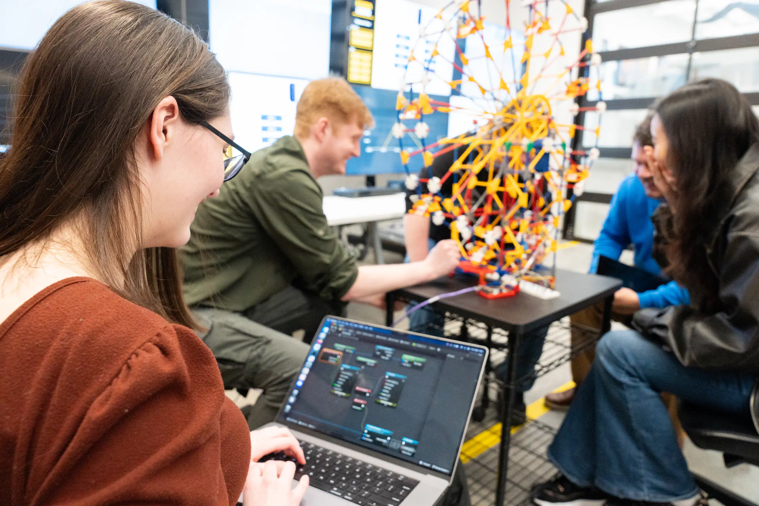 Students showing off a replicate model of a ferris wheel