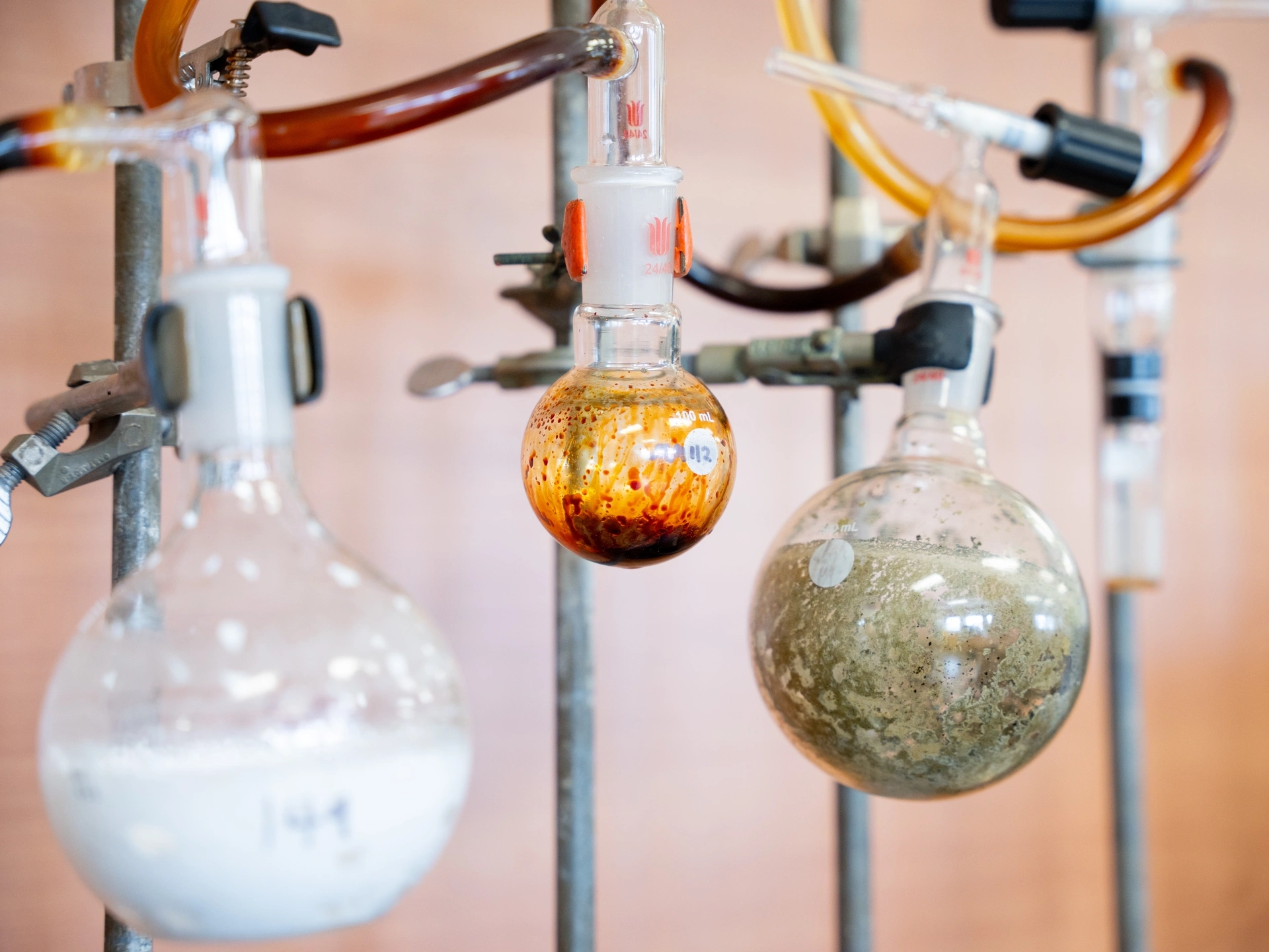 Circular vials and vial clamps suspended on pipes with tubes of fluid connecting them