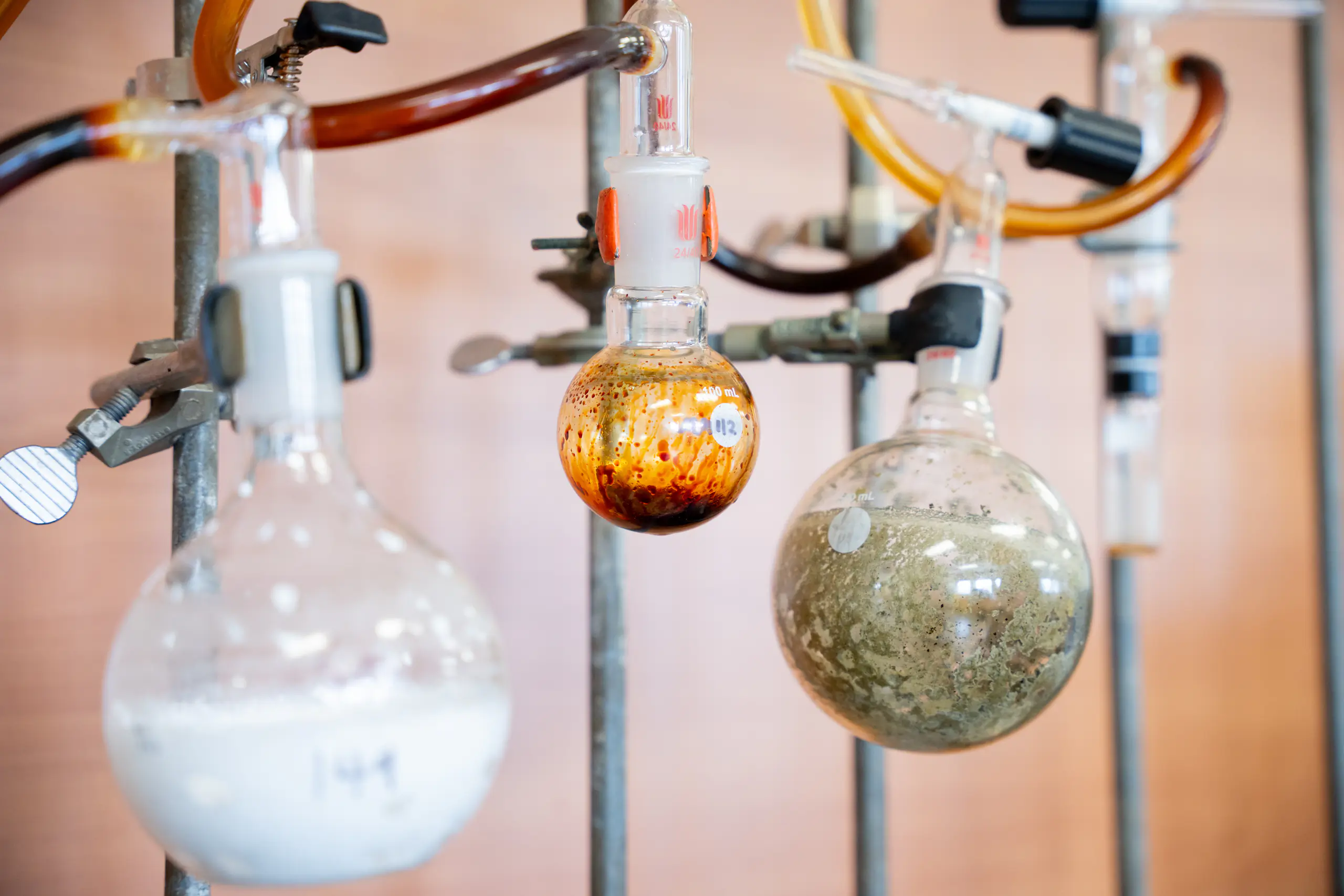 Circular vials and vial clamps suspended on pipes with tubes of fluid connecting them