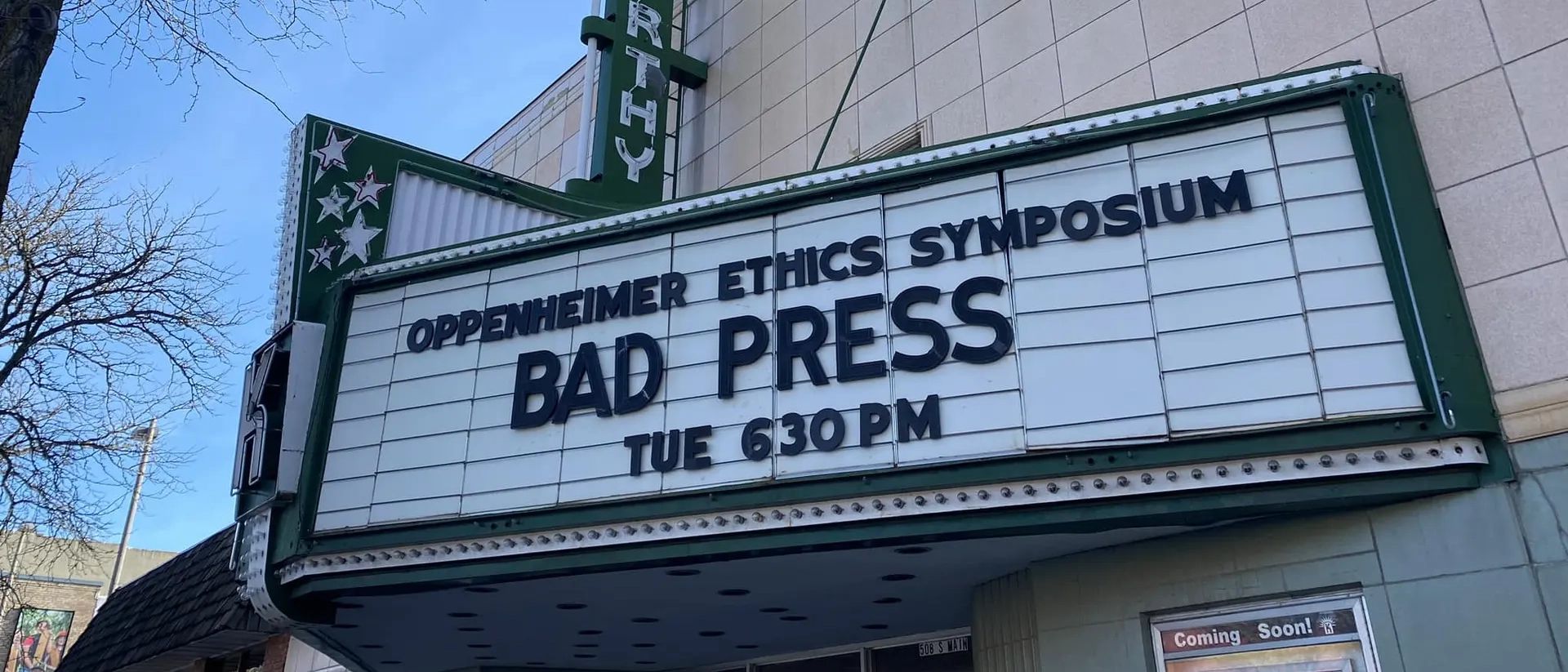 A marquee outside a cinema with showtimes for the Oppenheimer Ethics Symposium: Bad Press