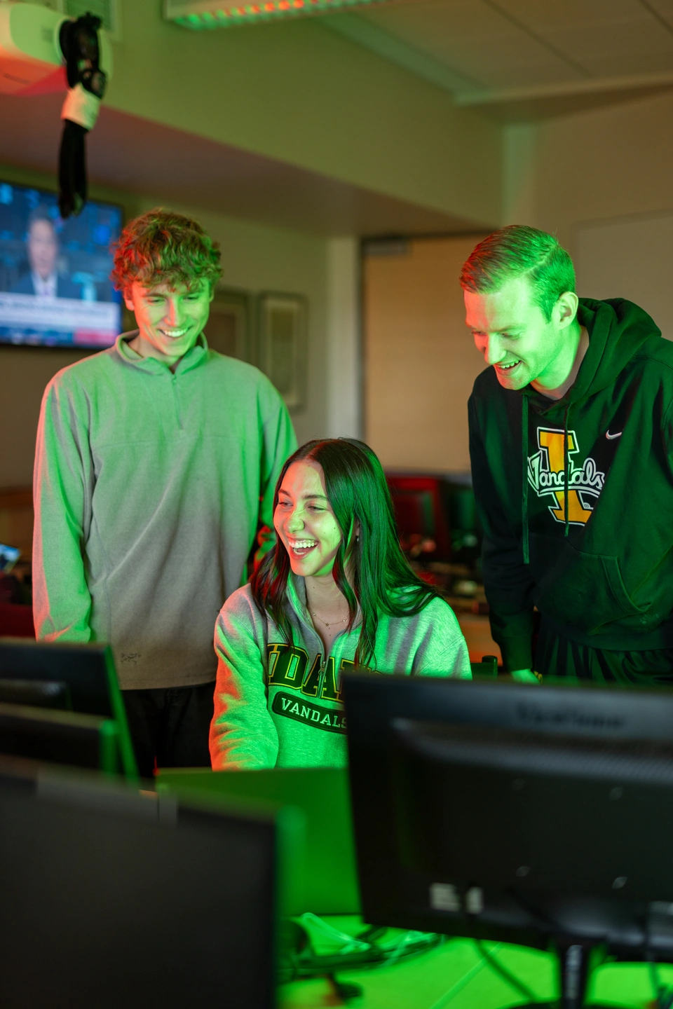 Catherine Hubinger and two other students study a screen showing stock market values. 