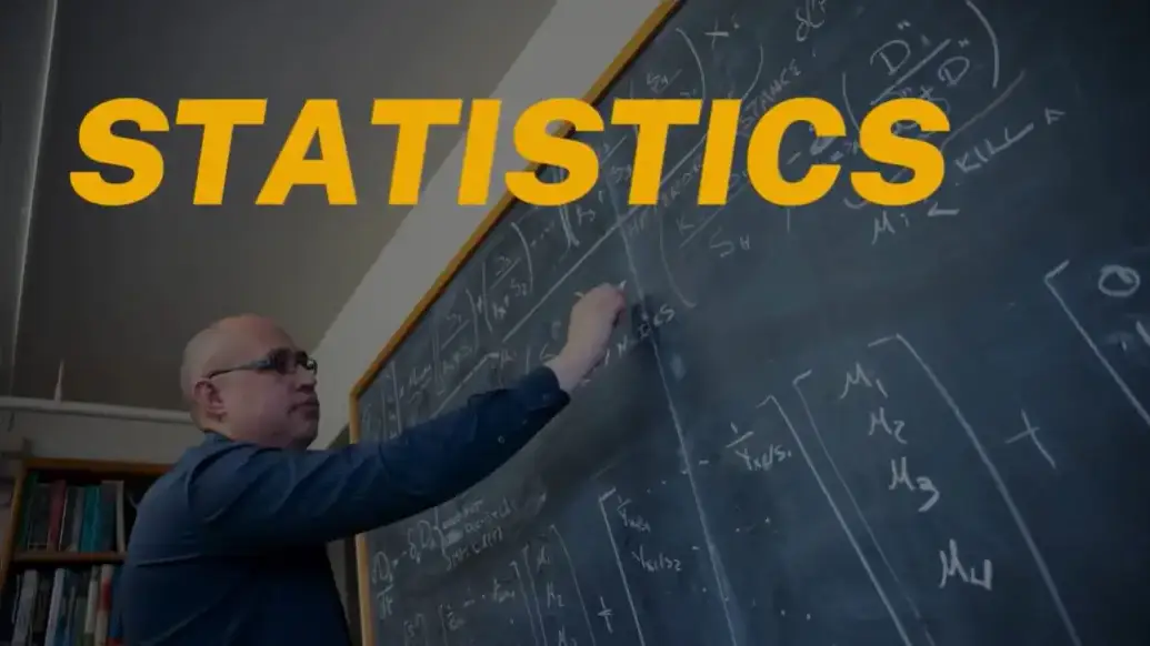Statistics thumbnail of a professor writing formulas on a chalkboard.