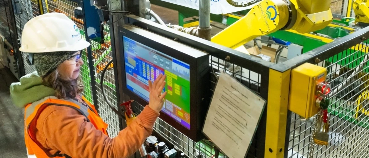 Person using touchscreen with hard hat on near heavy machinery