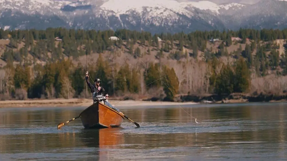 A man in a paddle boat in a lake