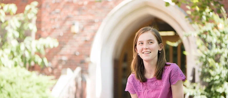 A University of Idaho English program graduate reads outside.