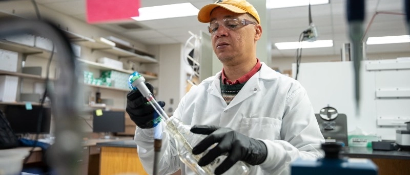 A man in a lab coat holding a test tube