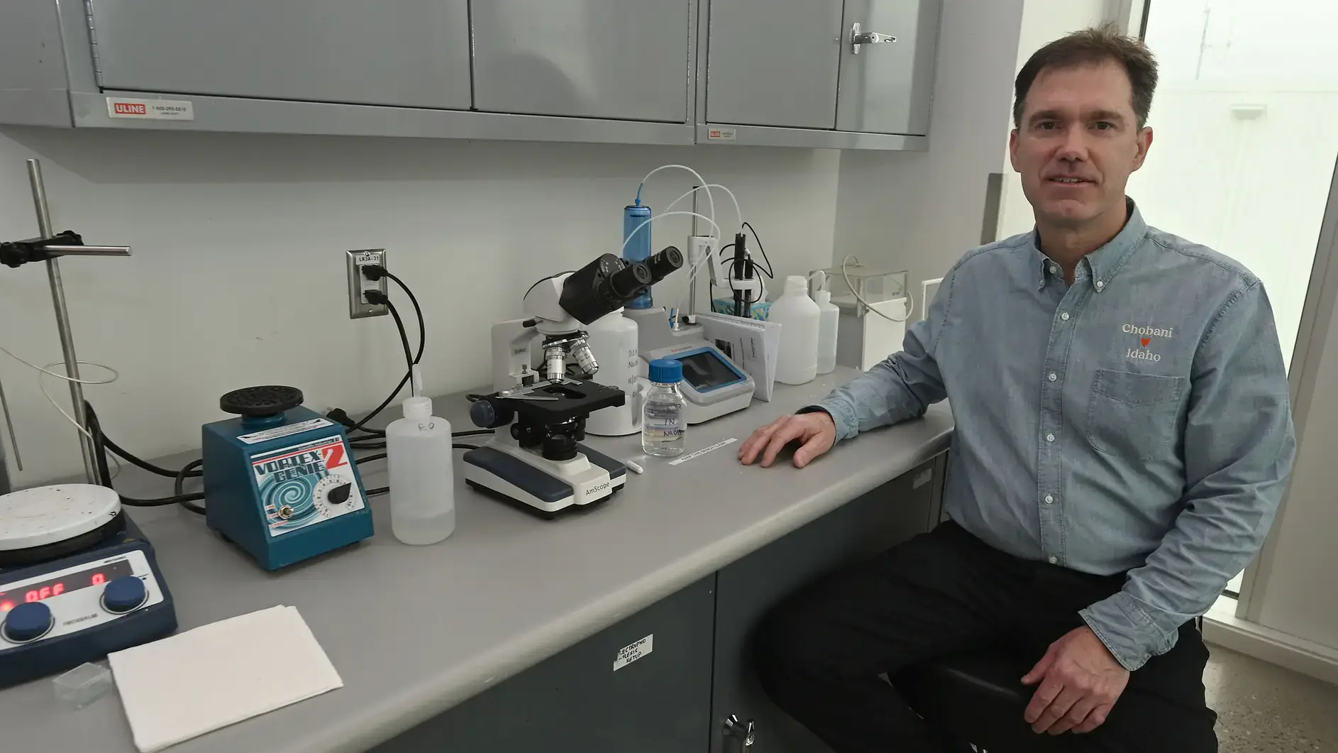 Peter Krell poses by a microscope.