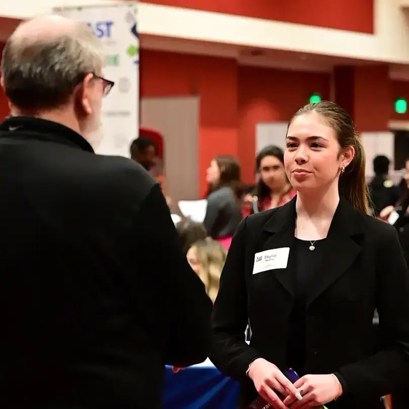 A woman talking to a man at a career event,