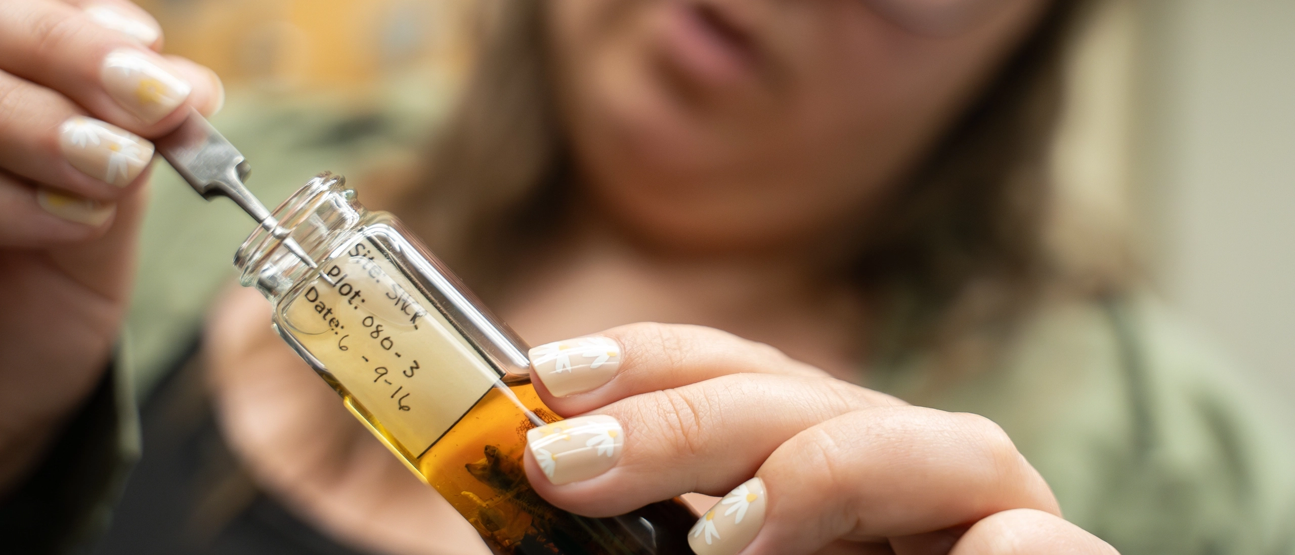 A lady holding a pick and a glass tube