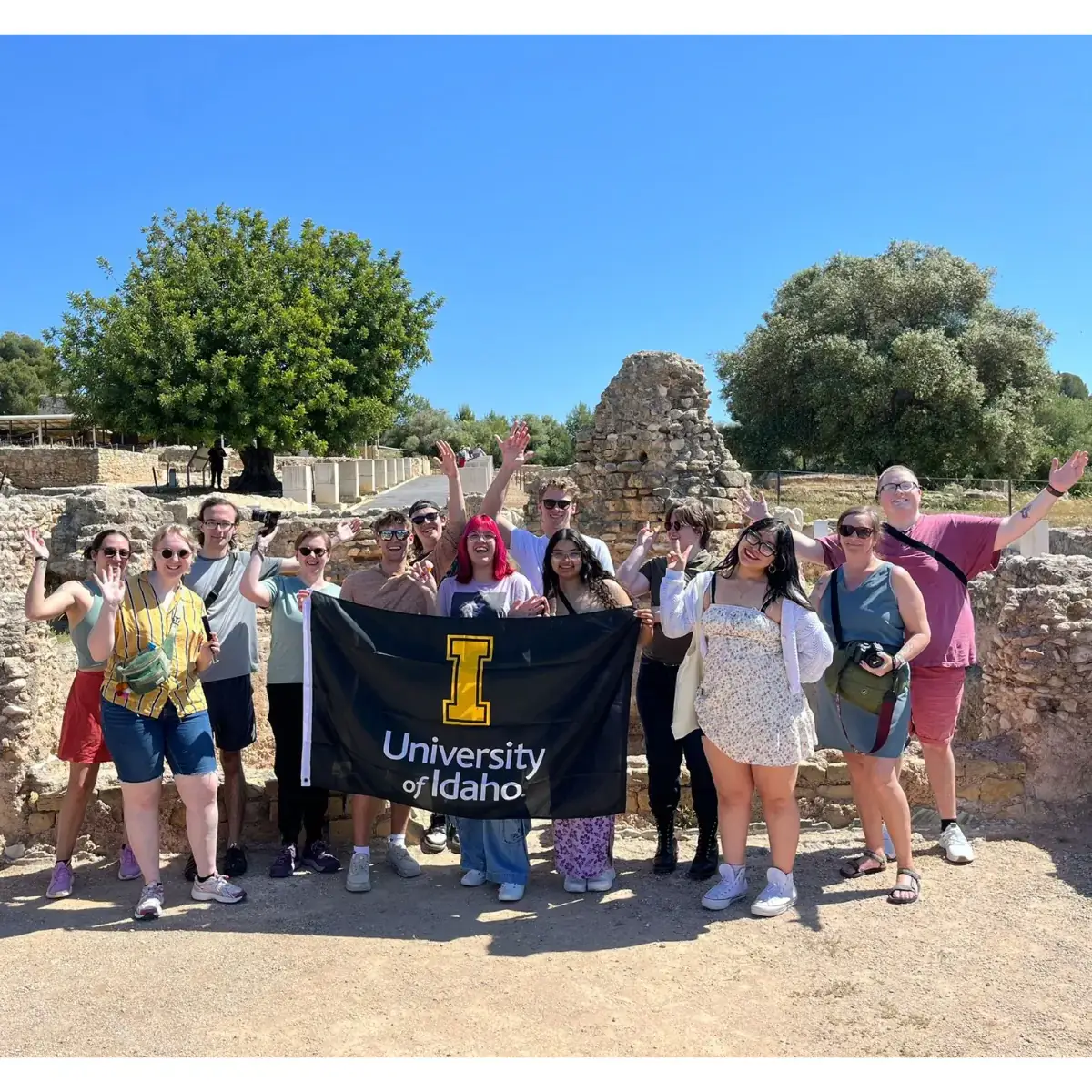 A group of friends holding a University of Idaho flag.