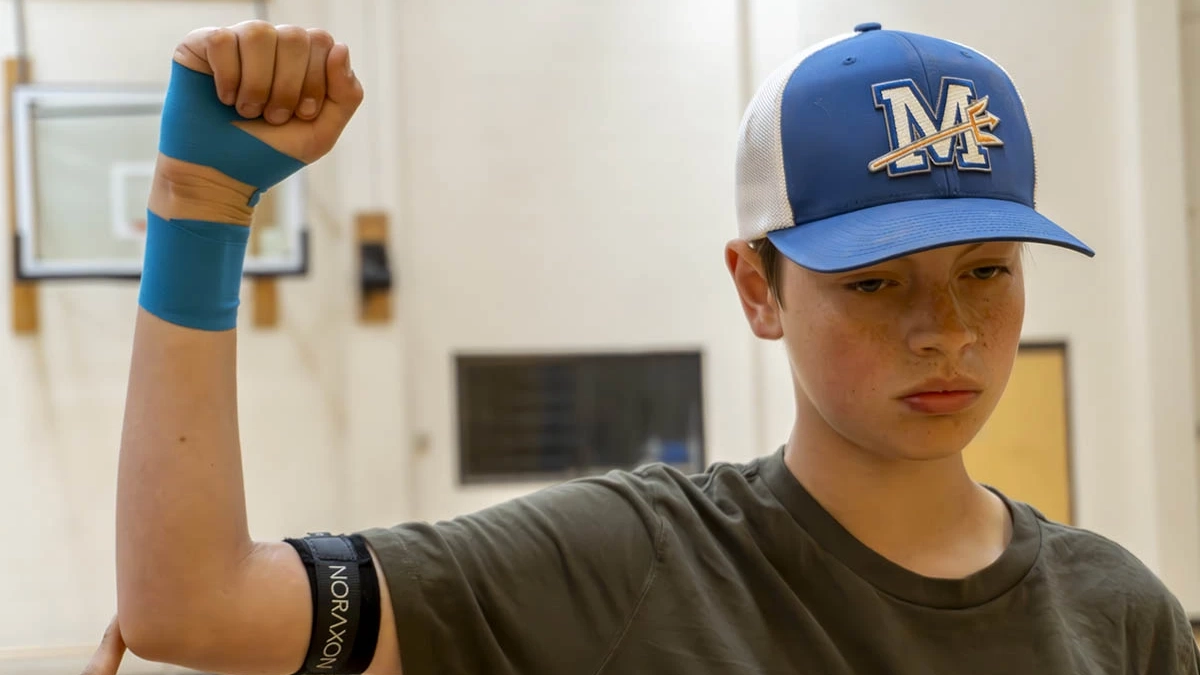 Young boy performing an arm stretch.