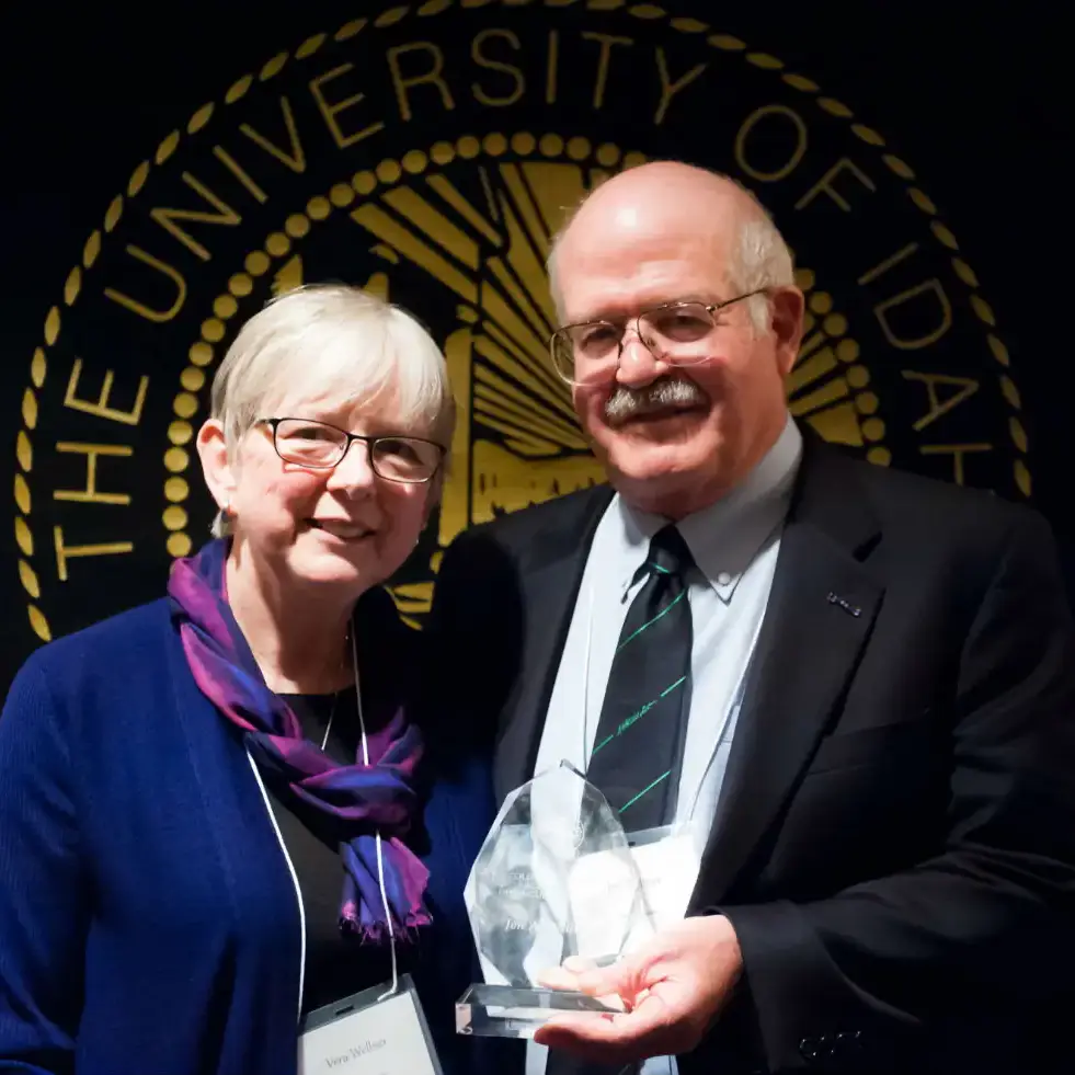 A man holding an award while standing next to a woman.