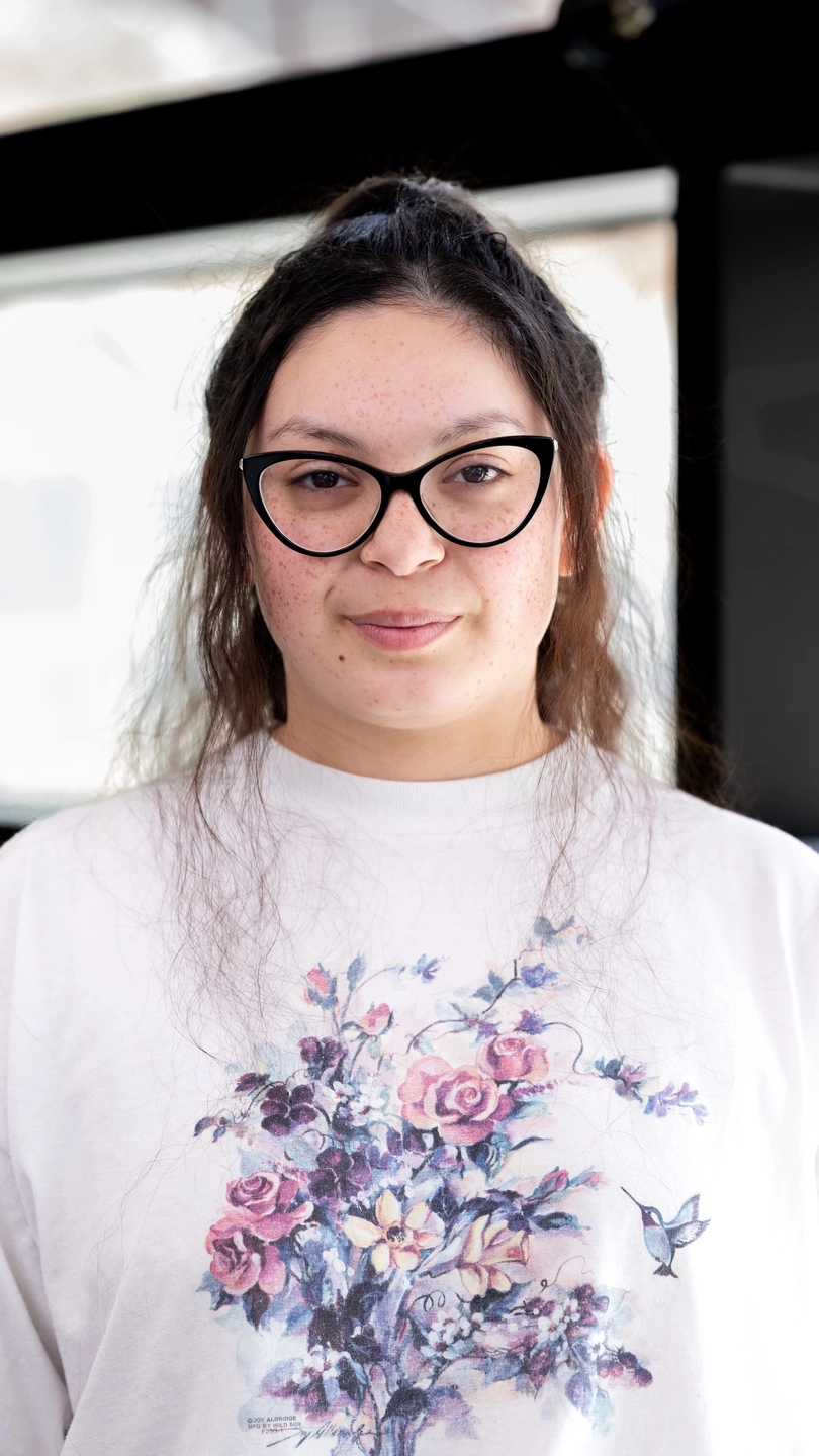 A head and shoulders photo of a woman with long dark hair wearing glasses