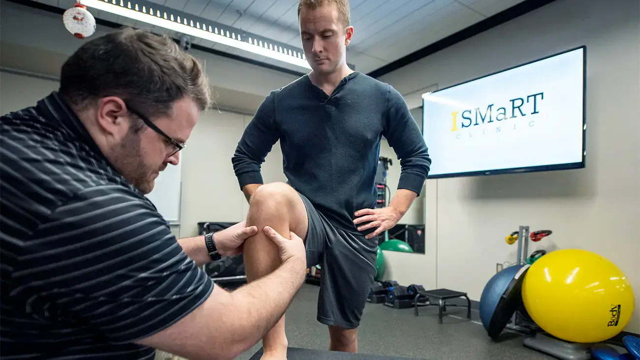 Pre-atheltic training student holding knee in an iSmart clinic setting.