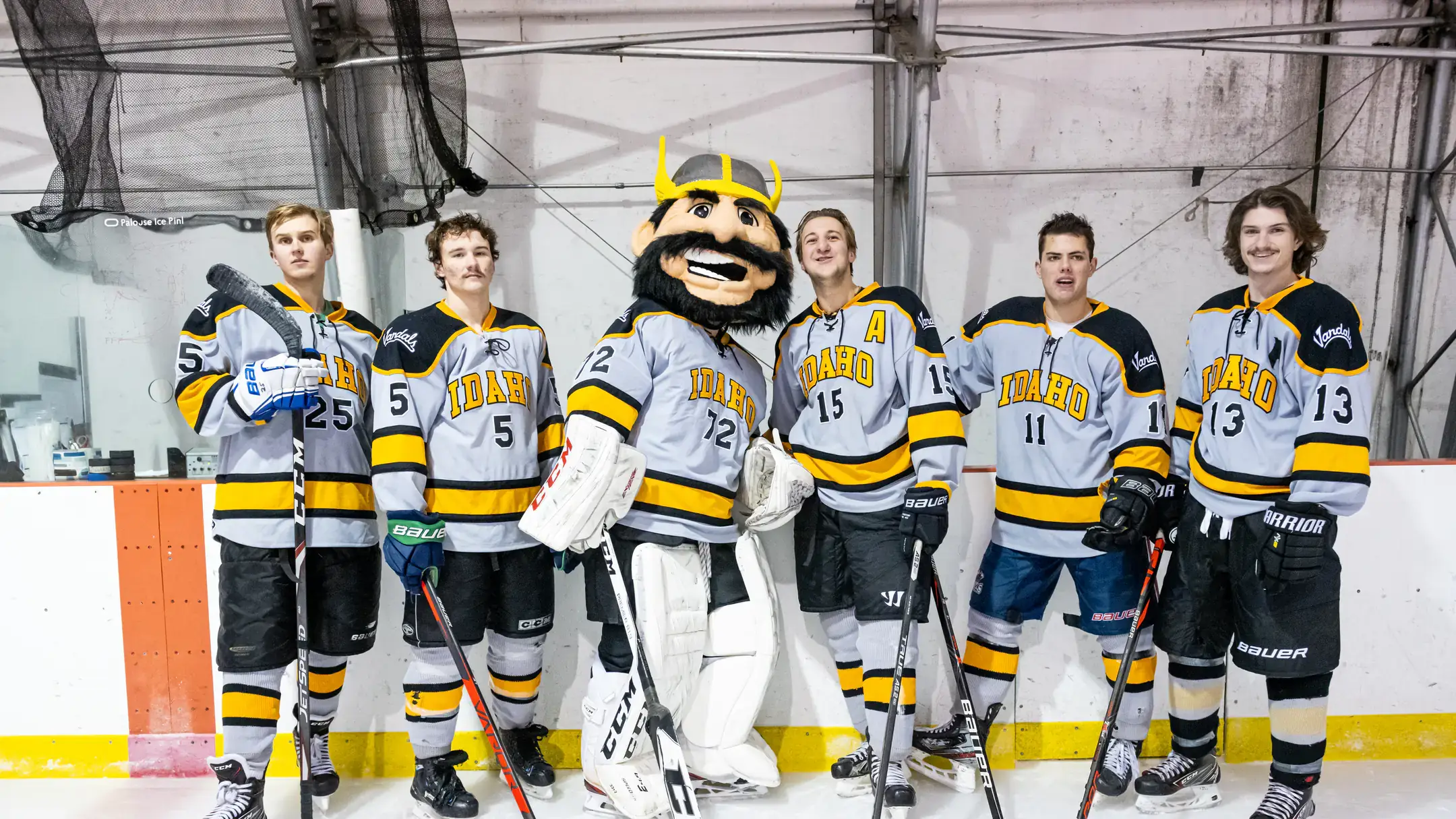 Joe Vandal in full hockey gear taking a team photo with the U of I hockey club