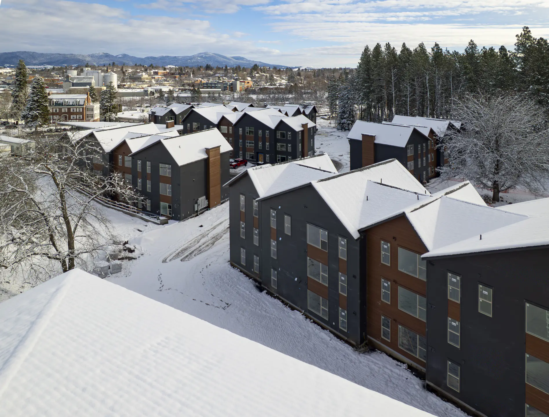 A skyline view of new multifamily housing units blanketed in snow.