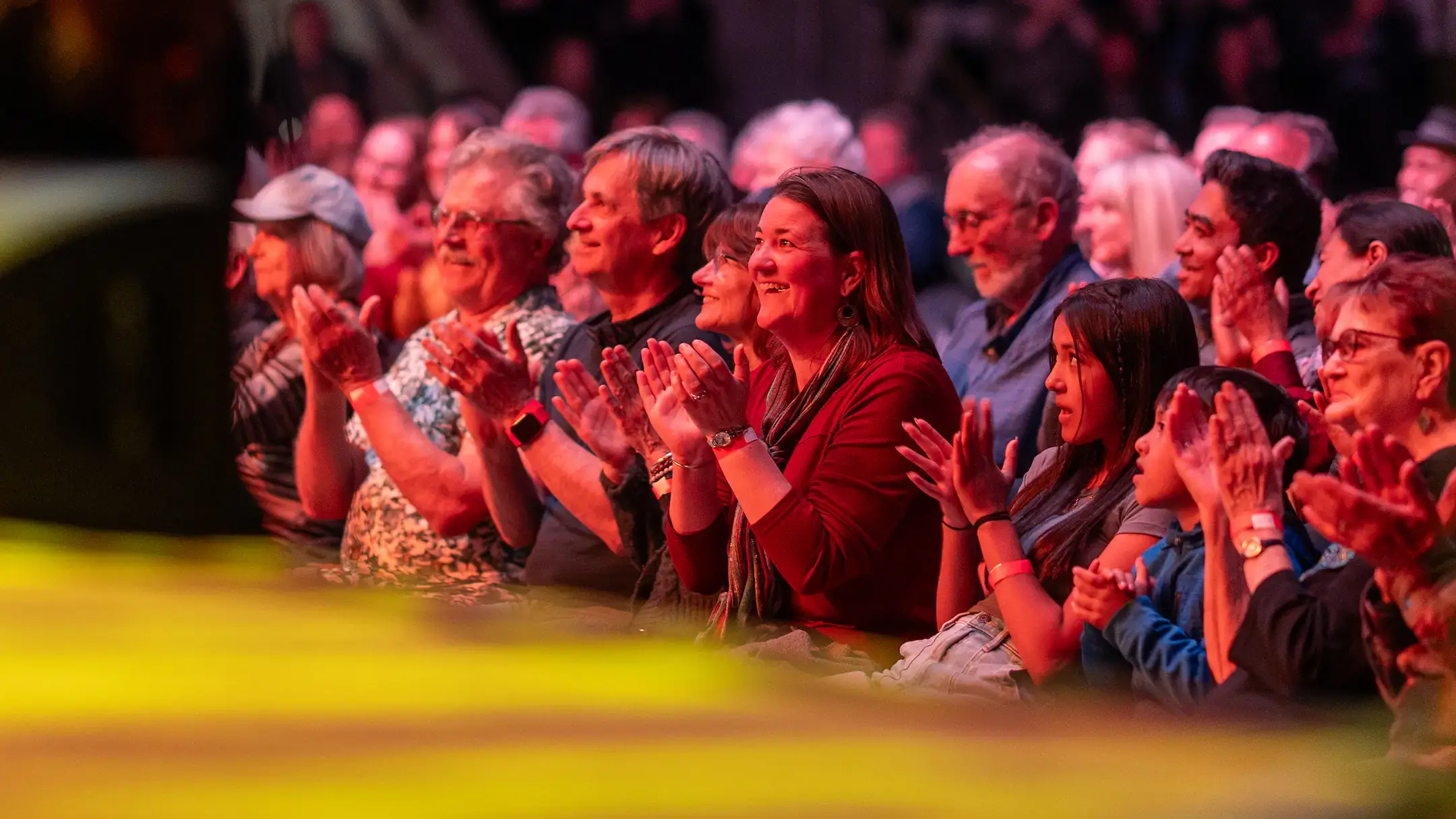 Crowds of people cheering while under neon lights