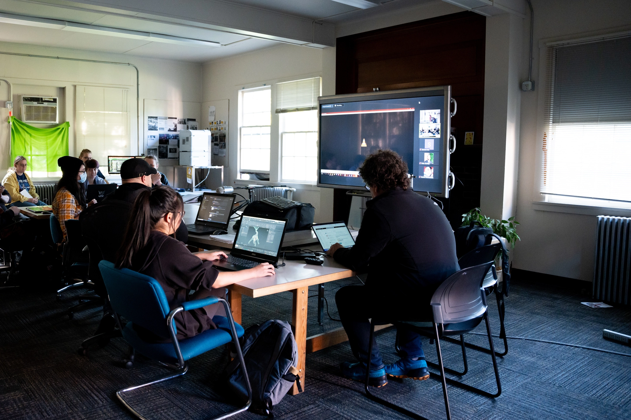 Photo of students and faculty reviewing video screen.