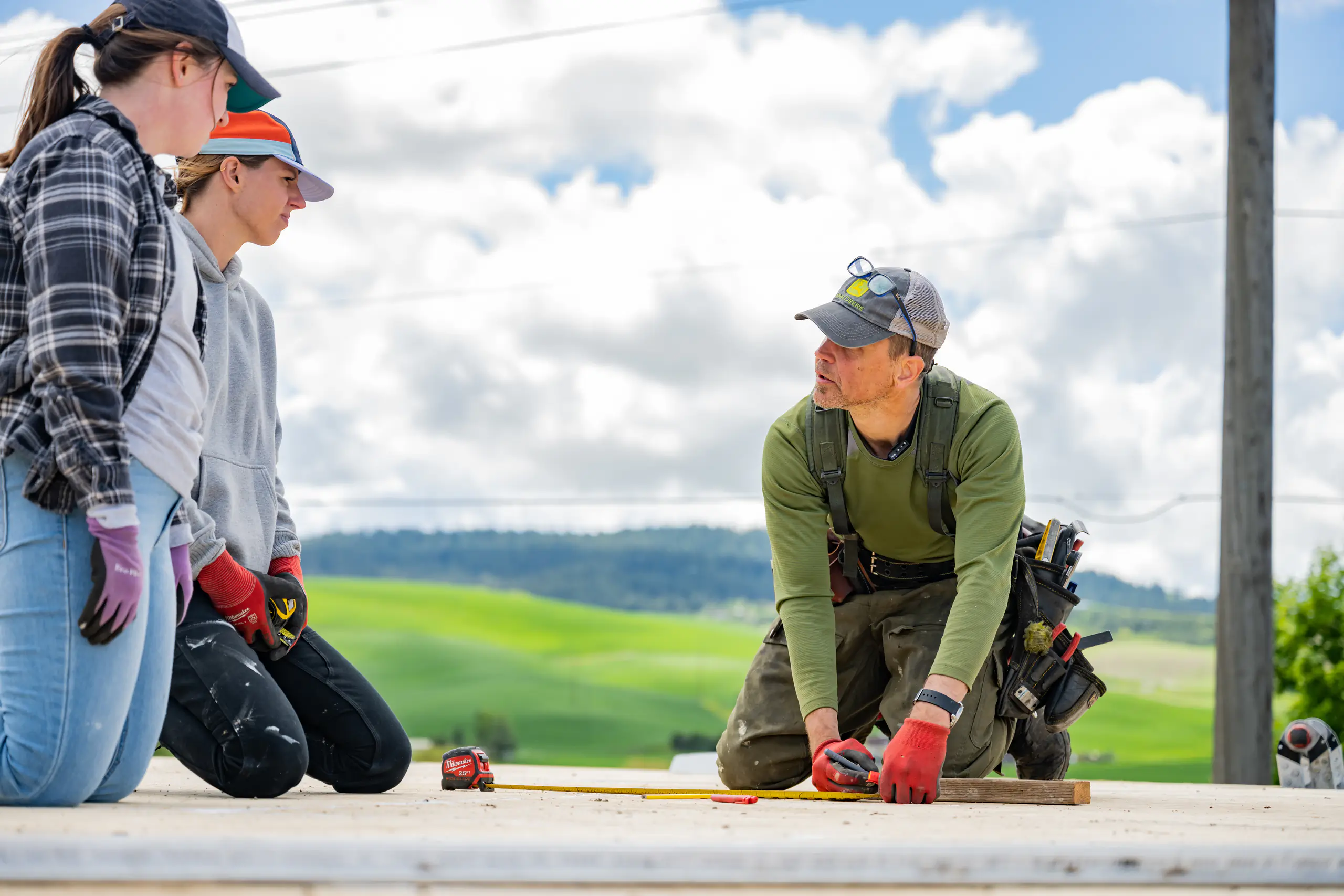 Three people working on house construction.