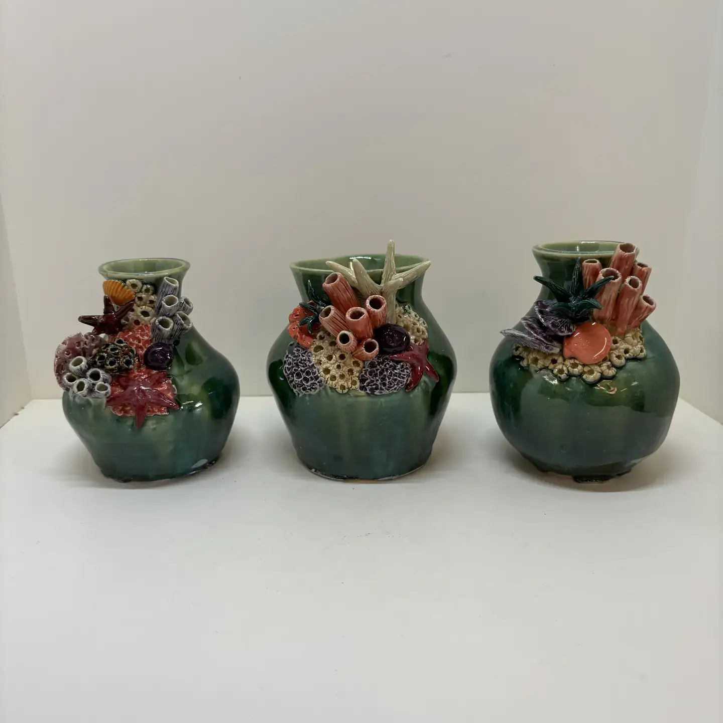 Three vases with coral and anemones designed on top