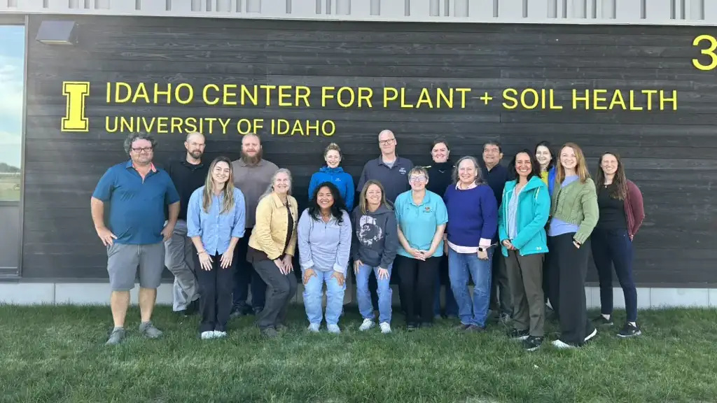 A group of scientists pose outside of a laboratory building.