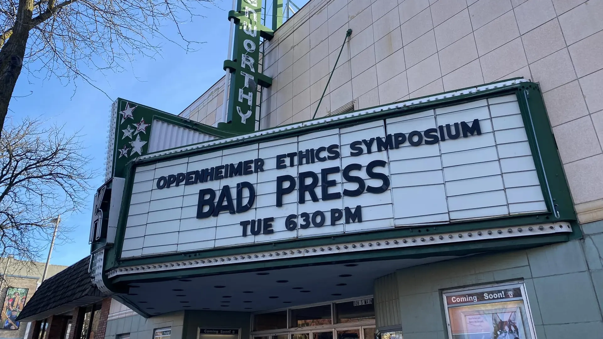 A marquee outside a cinema with showtimes for the Oppenheimer Ethics Symposium: Bad Press