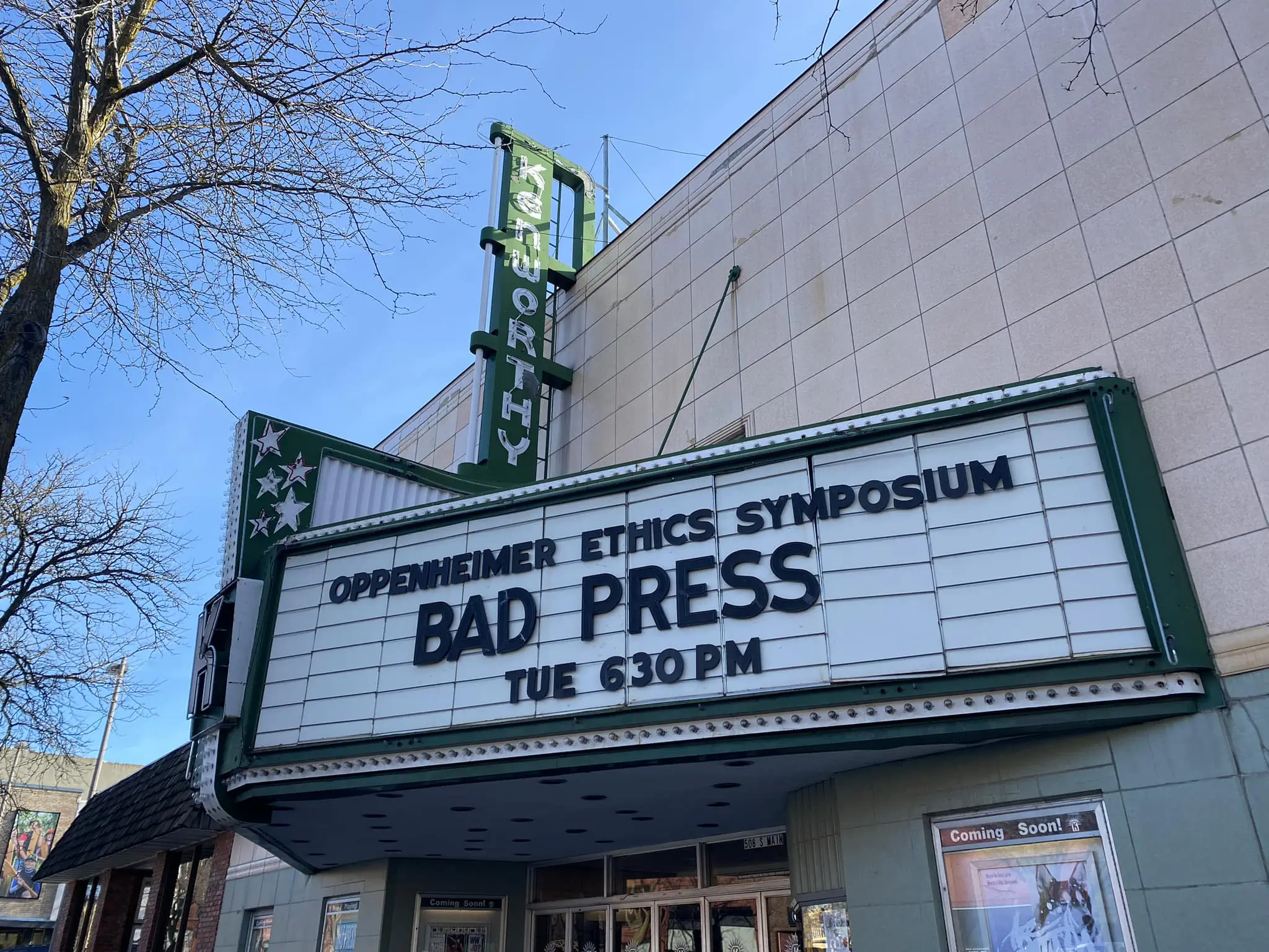 A marquee outside a cinema with showtimes for the Oppenheimer Ethics Symposium: Bad Press