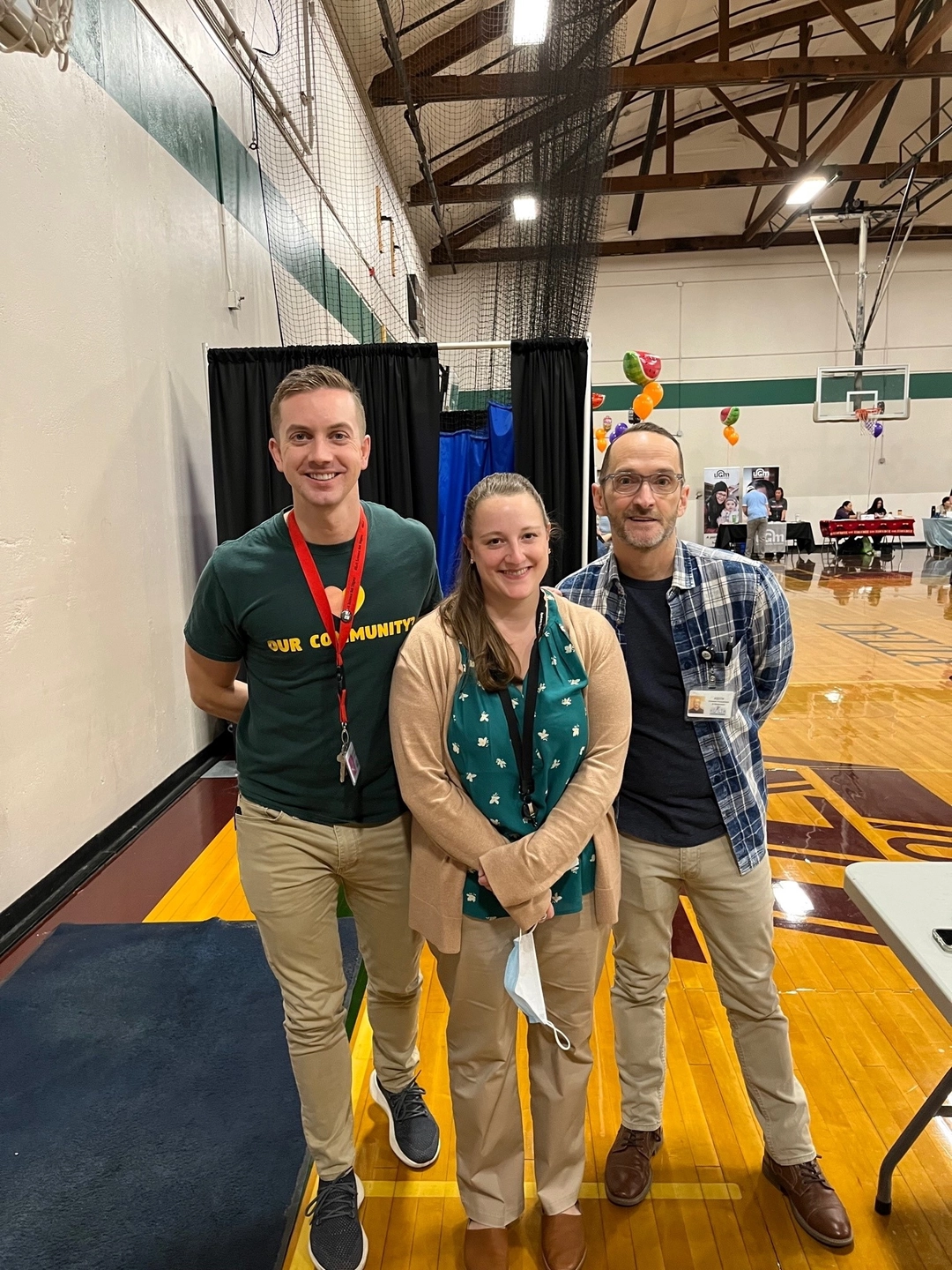 Three people at fair in school gym