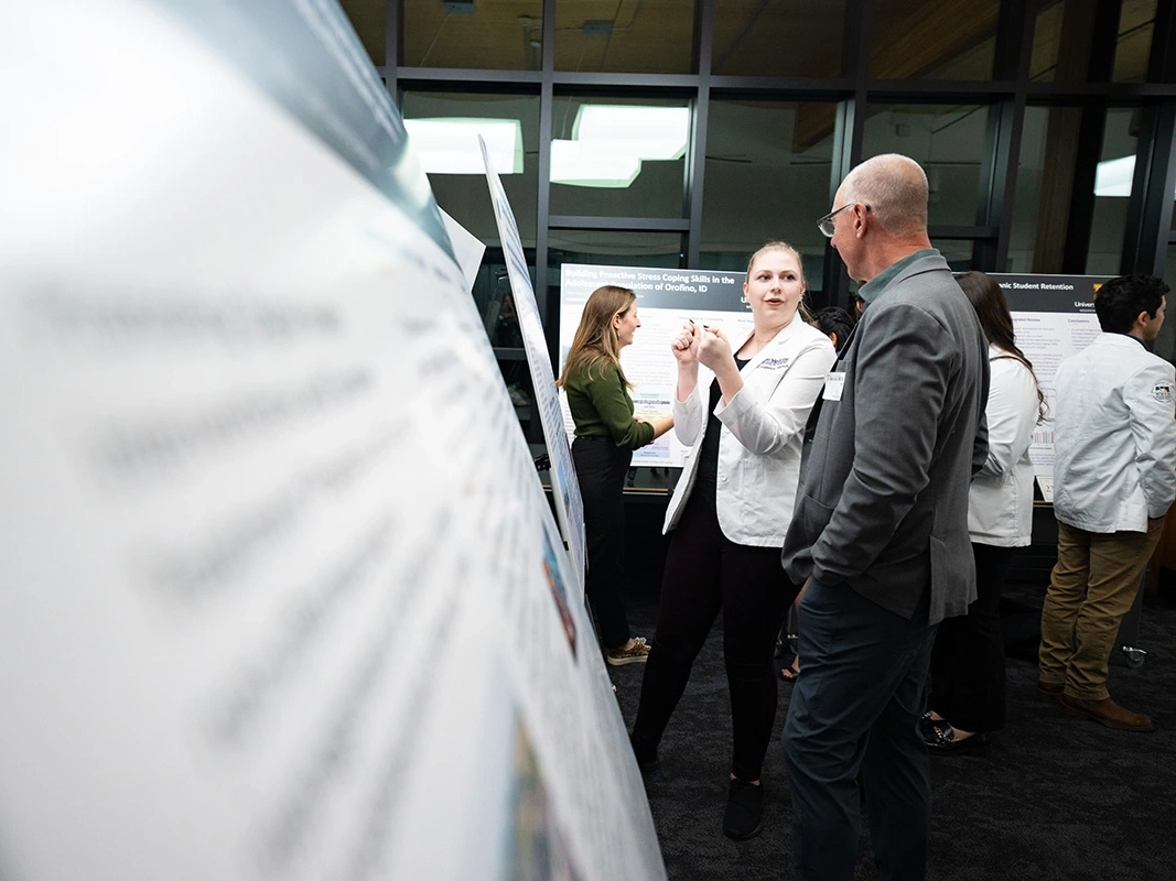 WWAMI student in white coat presenting her research project