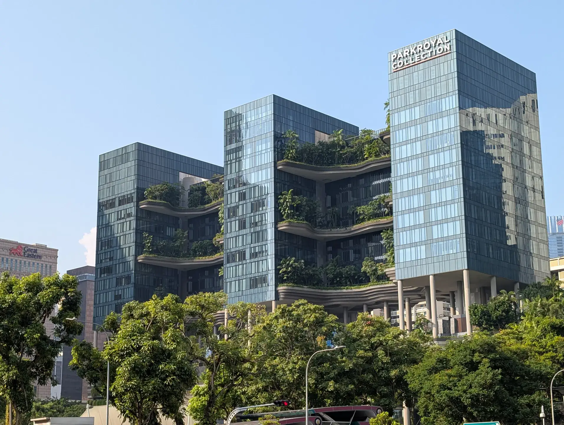 A three building hotel with trees and and bushes on it.