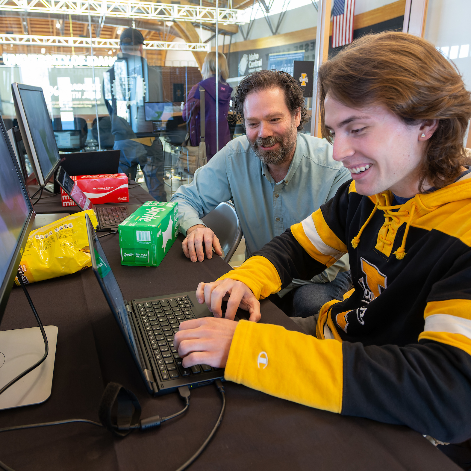 A teacher and a student sit at a computer