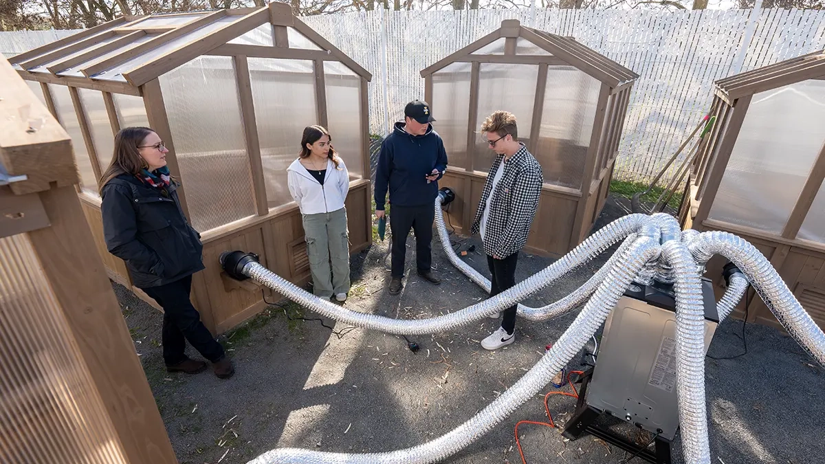 Students stand next to prototype smoke generators.