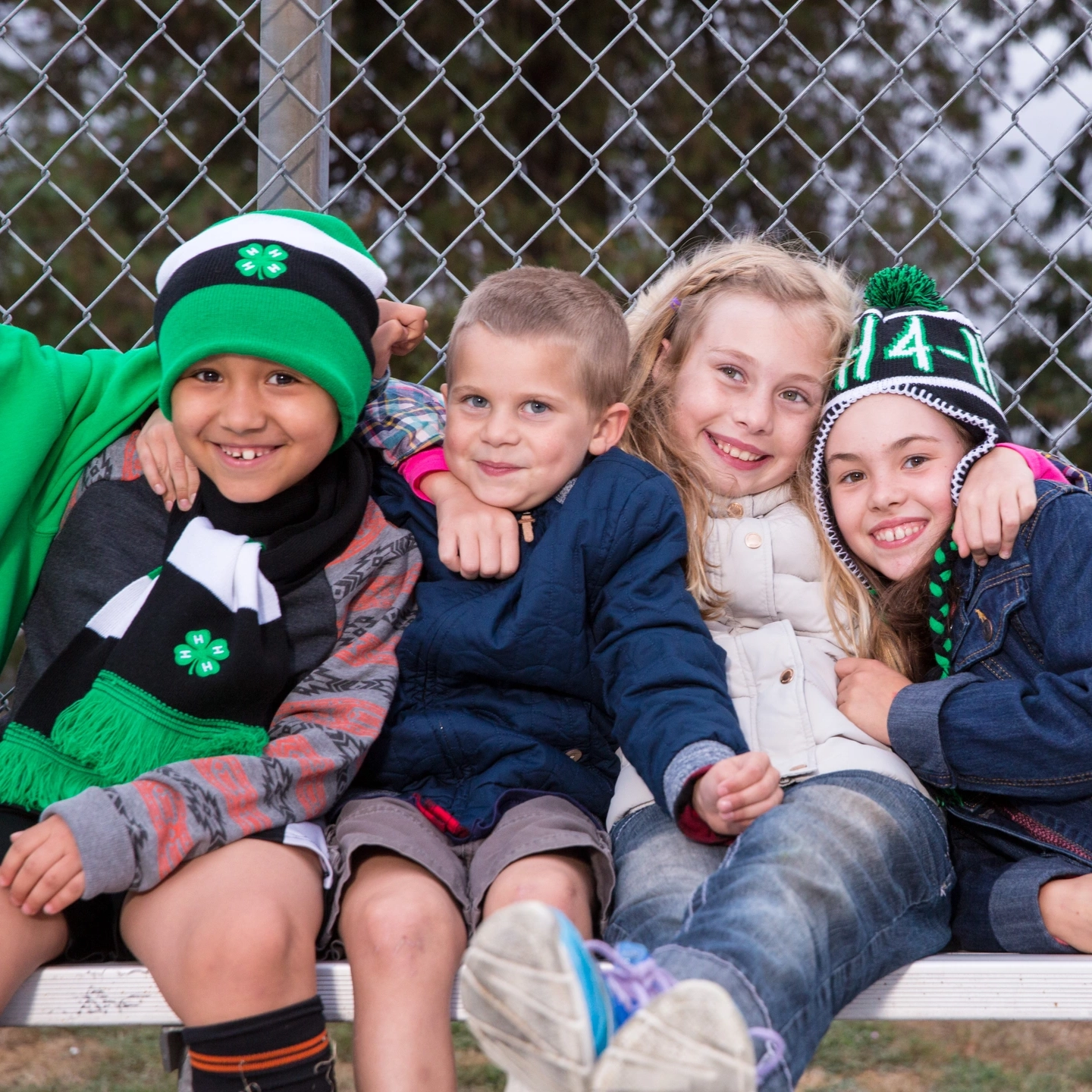 Children in 4-H apparel hold each other tight for a photo